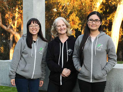 Susan Golden standing in between two students wearing BioClock Studio jackets
