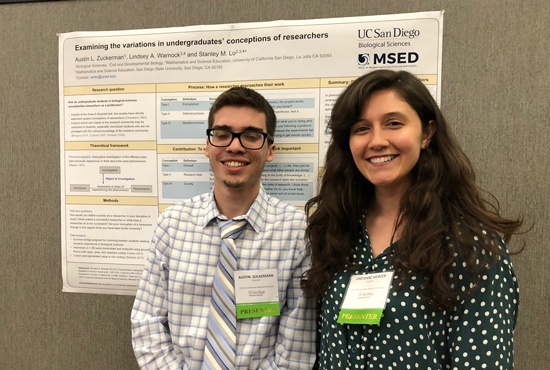 two students in front of a poster