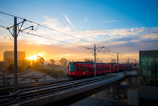 the San Diego Trolley running on a line with sunrise in the background