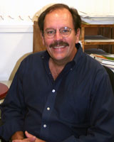 William McGinnis sitting at a desk in his office