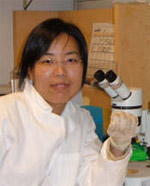 Yan Hu holding a microscope
