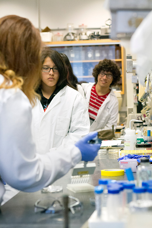 Emily Petty teaching students how to use a pipette in the lab