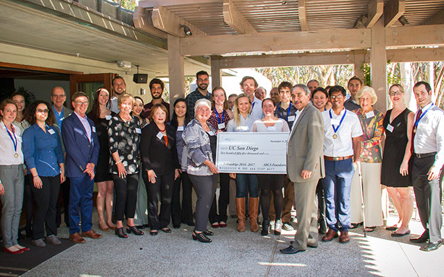 Adults standing and holding a check