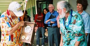 A member of Chuck's Shops crew presents him with a hand-crafted clock.