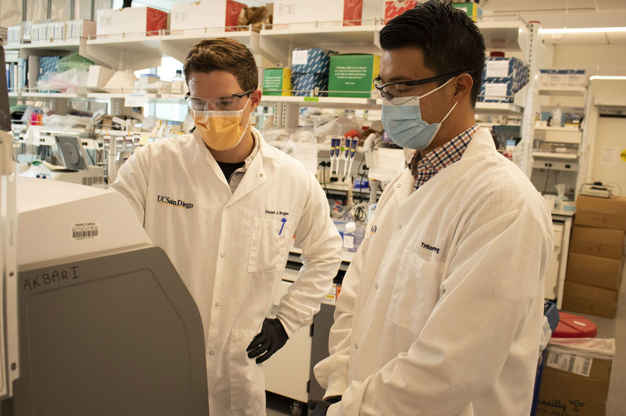 Study lead author Dan Brogan (left) and coauthor Calvin Lin review results from a SENSR reaction using a light cycler qPCR machine.